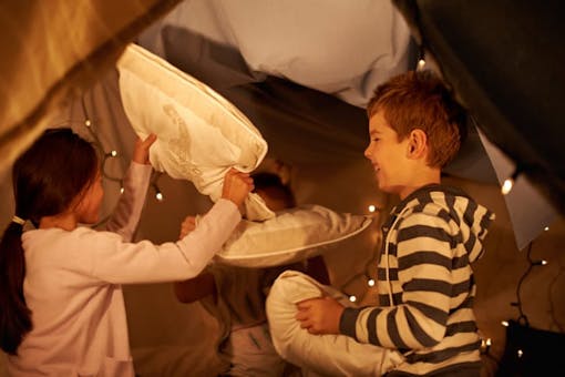 children playing inside a pillow fort