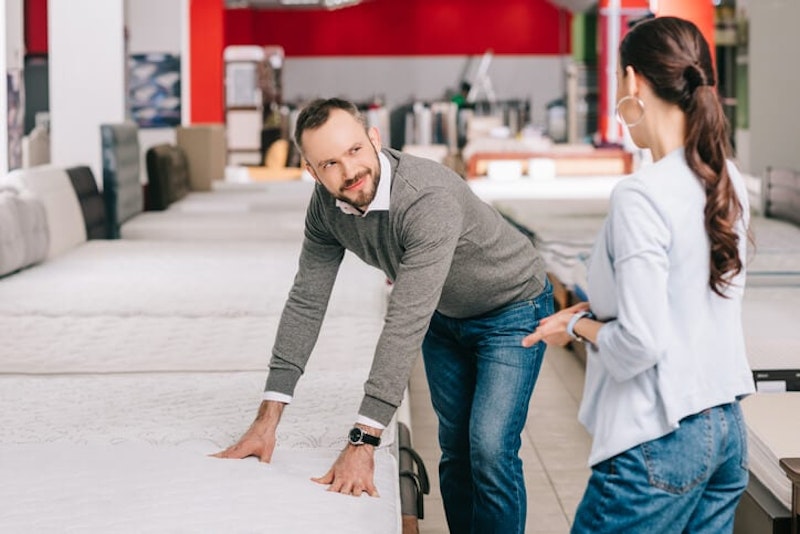 couple choosing a mattress in store